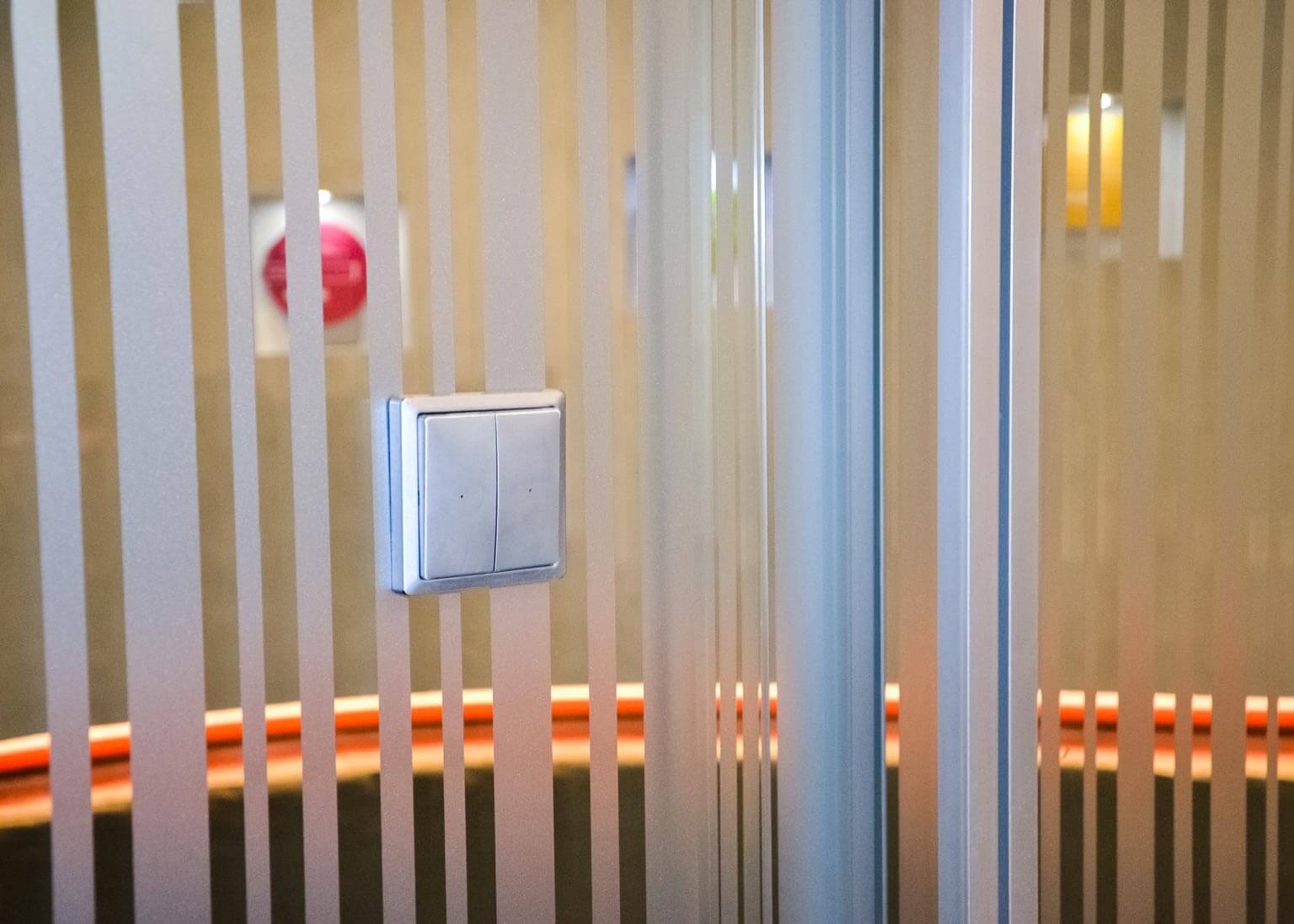 dettaglio interruttore luce wireless applicato su vetrata disegno franz siccardi sala riunione sede repower headquarter milano centro